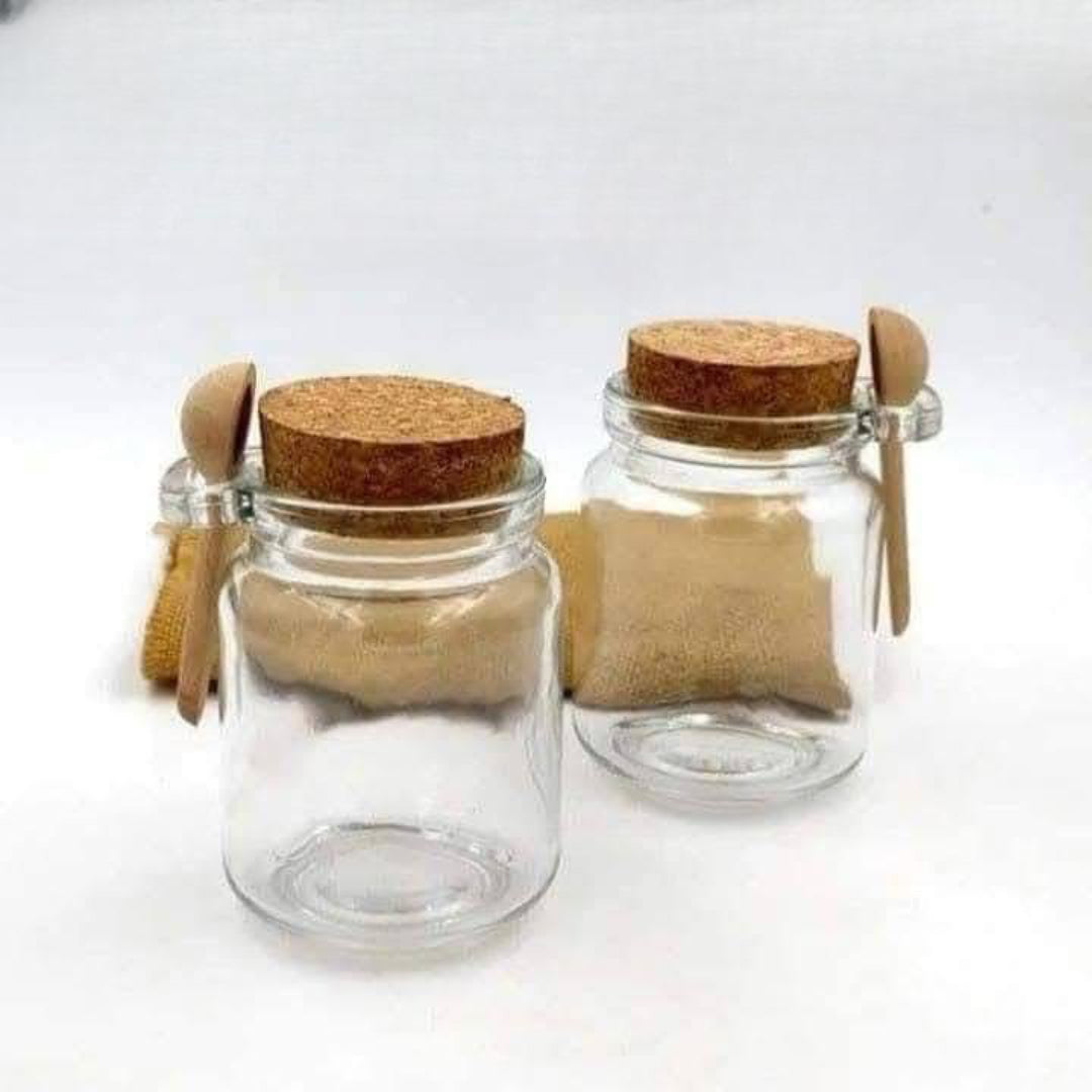 مرطبان زجاجي صغير مع غطاء فلين وملعقة خشب